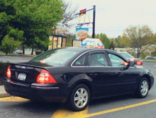Domino's delivery vehicle pulling up to a McDonald's drive-through window.